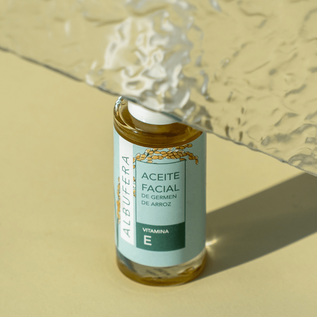 Sérum rejuvenecedor facial de aceite de arroz en su envase sobre un fondo verde