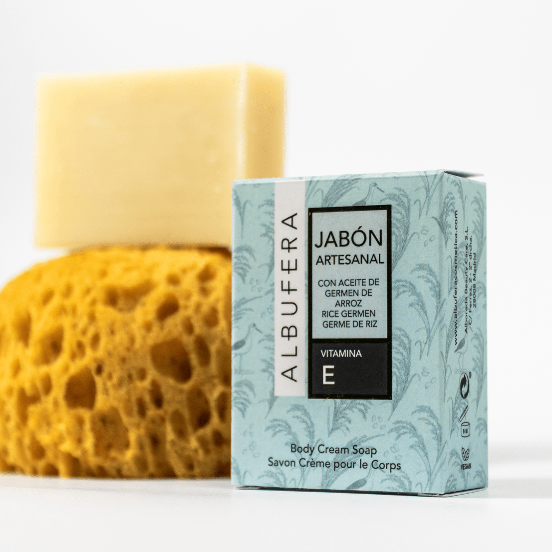 Jabón artesanal con aceite de germen de arroz, junto a su caja y sobre una esponja