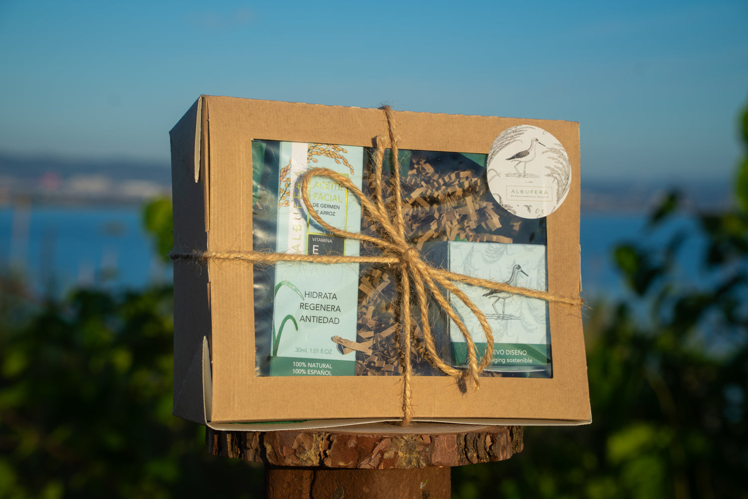 Pack de aceite facial de arroz Albufera y crema antiedad Albufera en su caja frente al parque natural de La Albufera